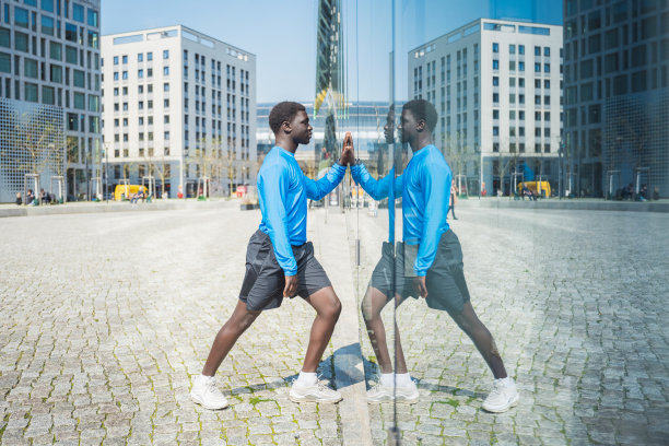 年轻的运动员在窗玻璃上反思图片下载