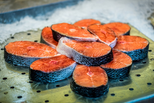 鲜红的冰鲜鱼，超市有售。鱼店的柜台上放着一份红鲑鱼的牛排和鱼片。图片下载