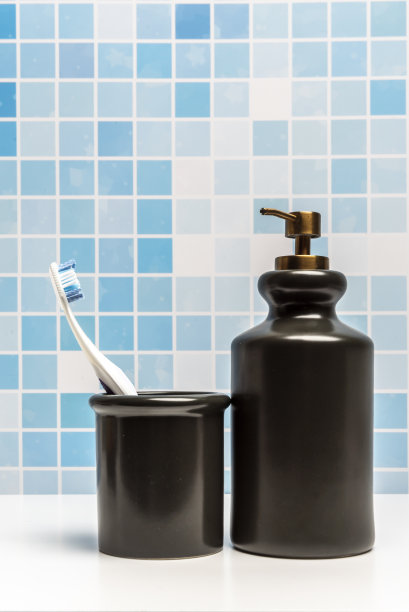 典型的浴室容器，用来装牙刷和其他物品，另一个容器装有液体肥皂的分配器图片下载