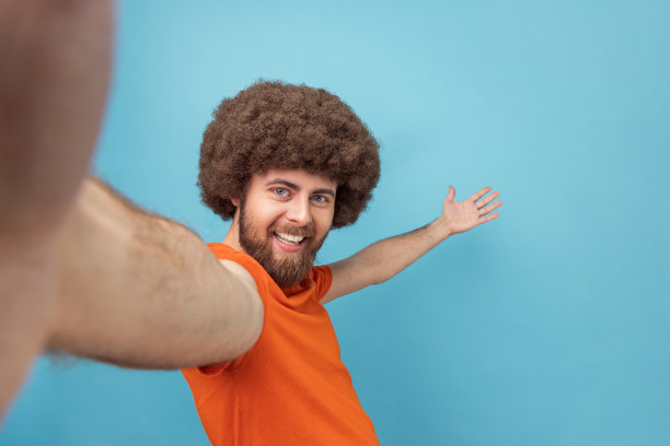 男子直播，与追随者交谈，邀请朋友，展示欢迎手势，POV。图片下载