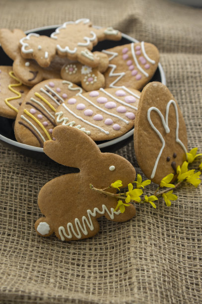 复活节的饼干盘上桌，用黄麻桌布，一组春天的姜饼彩绘图片下载