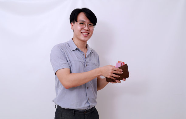 开心的亚洲人拿着印尼钞票和钱包看着镜头图片下载