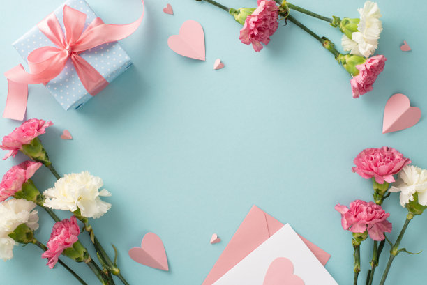 母亲节惊喜礼物概念。顶视图平躺照片美丽的礼物盒粉红色的丝带，康乃馨花，粉红色的纸心明信片在淡蓝色的背景与空白的空间图片下载