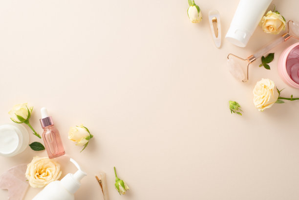概念化你的护肤程序，俯视图平面上有玫瑰装饰的瓶子按摩霜和精华液在柔和的米色背景上，为你的品牌需求留出空白空间图片下载