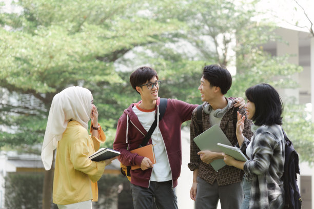 在课间休息的时候，一群不同种族的年轻亚洲大学生在校园里休息聊天。他们面带微笑，看起来很开心。图片下载
