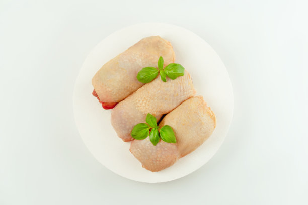 食品的概念。前视图。鸡腿肉。生的新鲜的带皮的鸡腿肉和新鲜的香草在白色的背景。副本的空间。零售食品。设计师采购。有机食品，健康饮食。图片下载