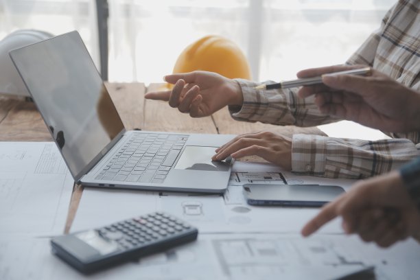 两个商人工地工程师。工程对象在工作场所与合作伙伴在后台进行交互图片下载