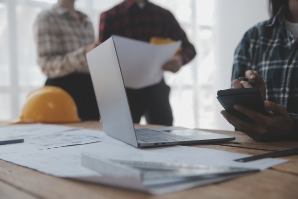 两个商人工地工程师。工程对象在工作场所与合作伙伴在后台进行交互图片下载