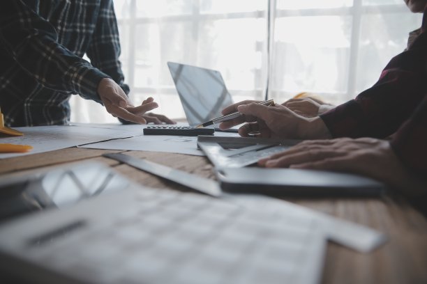 两个商人工地工程师。工程对象在工作场所与合作伙伴在后台进行交互图片下载