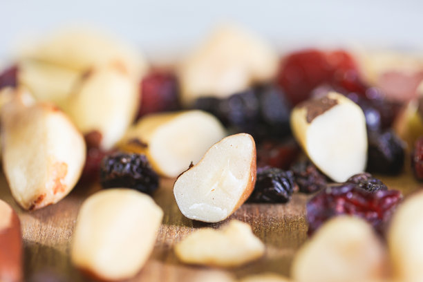 板栗、巴西坚果和葡萄干混合在一块木板上的微距照片。图片下载