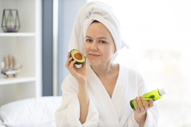 女性在卧室里拿着牛油果和化妆品油瓶图片下载