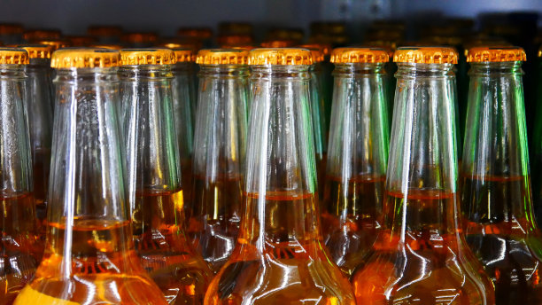 商店的特写镜头里有许多带着金色瓶盖的玻璃窖藏啤酒图片下载