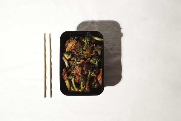 中餐馆的牛肉和西兰花，黑色外卖盒图片下载