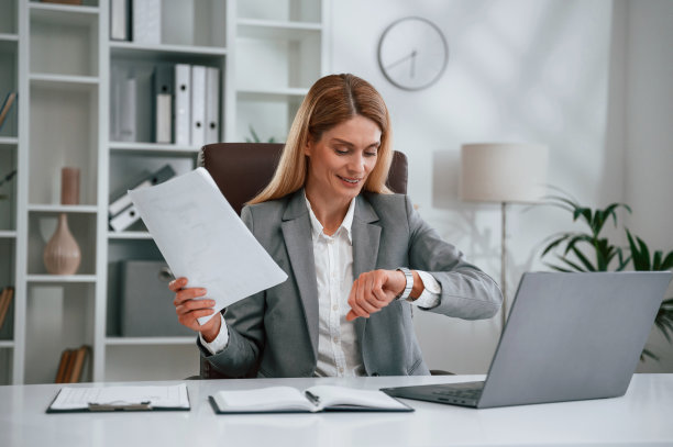 核对时间，拿文件。穿着正装的女士正在办公室工作图片下载