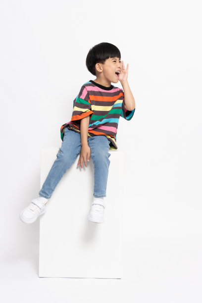 亚洲小男孩坐在白色的盒子上，张开嘴，双手尖叫着，孤立在白色的背景下，5岁图片下载