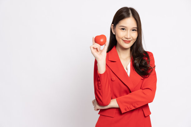 年轻的亚洲女商人拿着红心，孤立在白底上图片下载