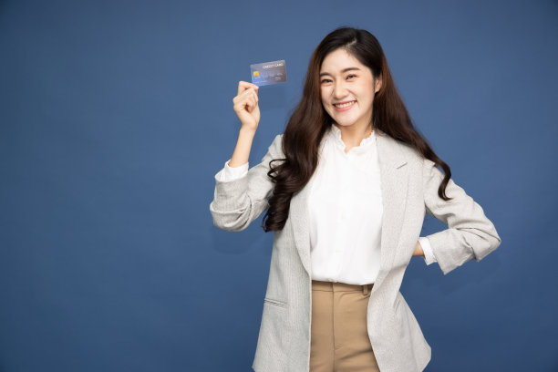年轻的亚洲女商人微笑着，展示，出示信用卡进行支付或在线支付业务，蓝色背景孤立图片下载