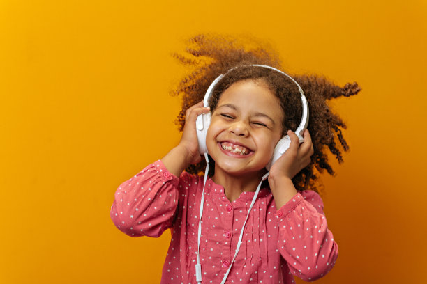一个戴着耳机的黑人小女孩听着表达真实情感的音乐。图片下载