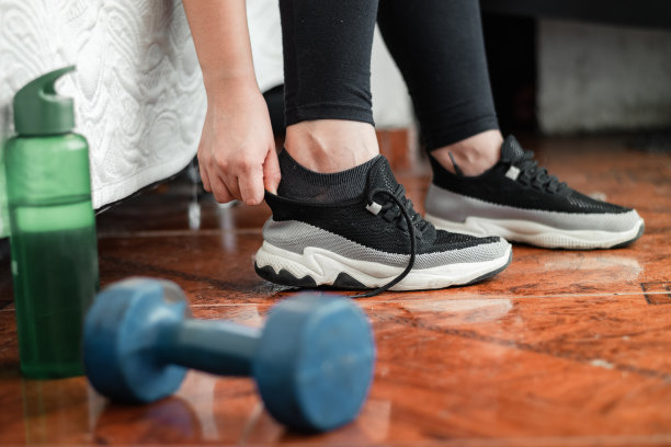 一个女人在出门跑步前在家里穿运动鞋的详细照片图片下载
