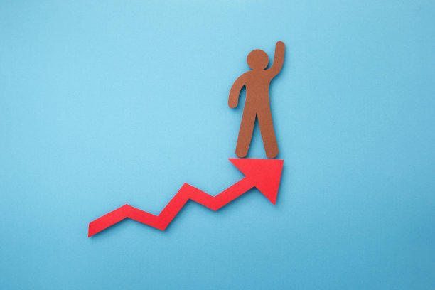 举手的人站在蓝色背景剪纸的红色箭头上。图片下载