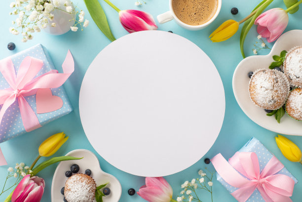 用一种时尚的方式庆祝母亲节。在淡蓝色背景上的纸杯蛋糕、礼物和郁金香的俯视图。使用空圈来宣传你的信息或添加一个特别的问候图片下载