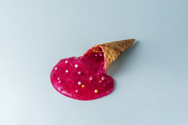 创意甜食概念。冰淇淋从华夫蛋筒里滴到蓝色地板上。图片下载