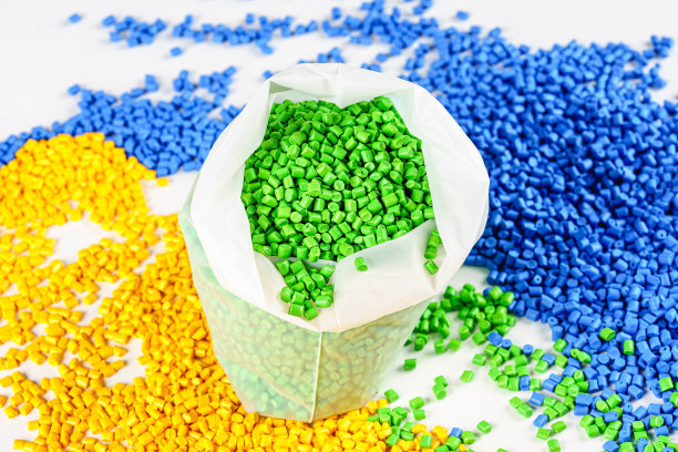 用于塑料颗粒的黄色、蓝色和绿色染料。聚合物生产材料。化学工业。图片下载
