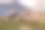 明亮的夏日山景——乡村道路上有裂缝的黄色巨石，绿色的草地，高高的粉红色岩石悬崖，在晴朗的日子里，蓝天，蓬松的白云。在达吉斯坦旅行。图片下载