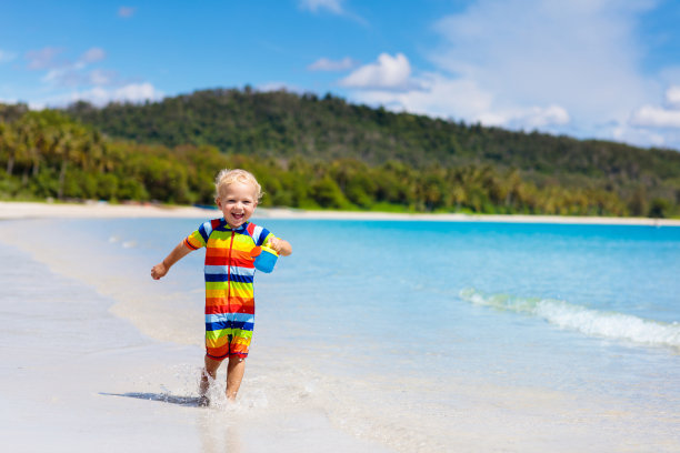 孩子们在热带海滩上玩耍。沙子和水的玩具。图片下载