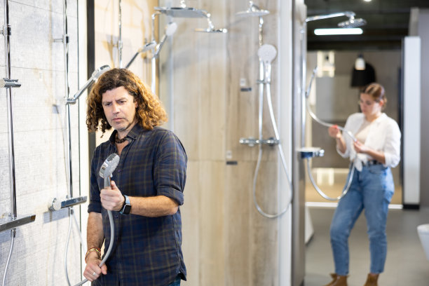 自信的男人挑选新的淋浴系统在商店图片下载