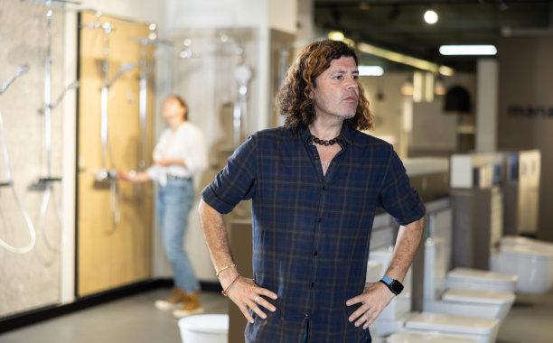 在管道部，一个男人在考虑为新公寓选择合适的浴室图片下载