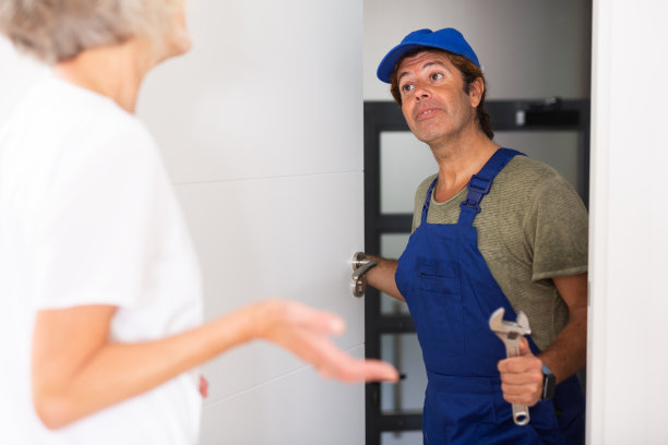 熟练的男水管工与女房主交谈图片下载