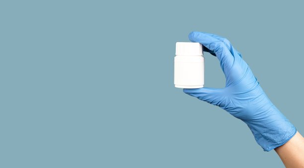 手持药丸罐模型在蓝色医疗横幅背景图片下载