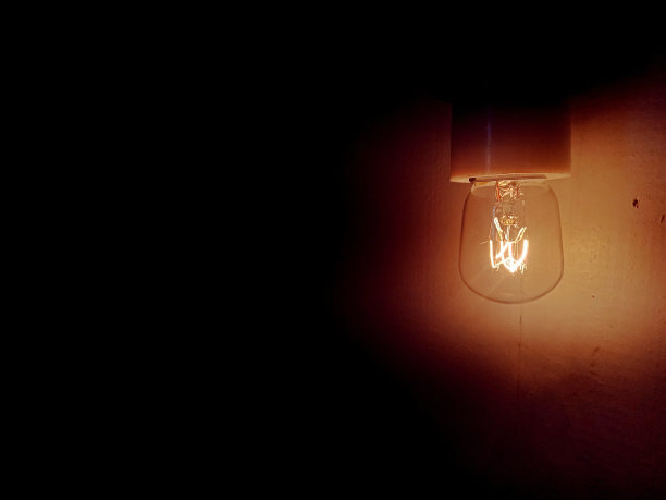 一个灯泡在黑暗中的画面图片下载