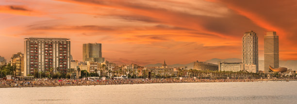 一群人在西班牙巴塞罗纳海滩的沙滩上晒日光浴图片下载