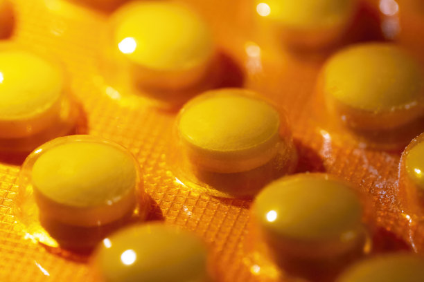 特写，宏观视角的吸塑包装药丸，橙色的药物维生素，抗生素，止痛药，药片包装，软焦全画幅图片下载