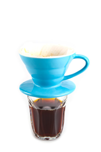 软蓝色滴杯里滴着咖啡，咖啡水流入下面透明的咖啡杯，隔离在白色的背景上图片下载