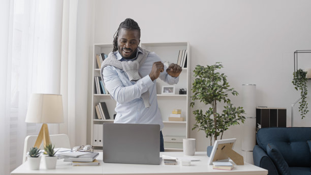 一名非洲裔美国男子在接到一份新的大订单后，正在他的家庭办公室里跳舞图片下载