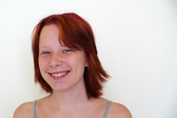 一个笑着的红发少女在白色背景上的肖像图片下载