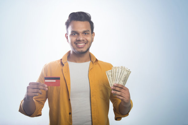 一个站着的年轻人的画像，两只手拿着信用卡和现金图片下载