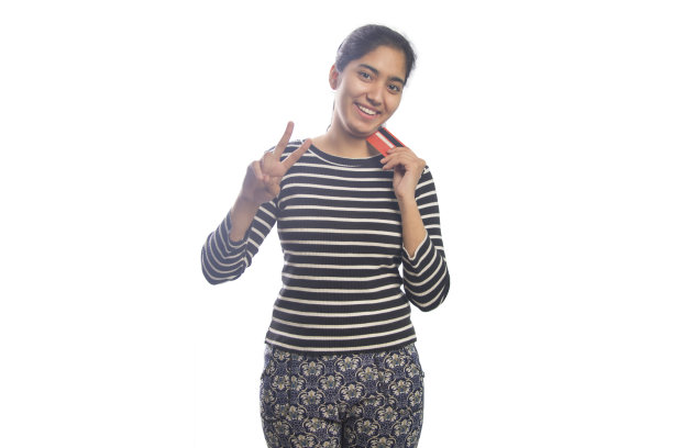 快乐的年轻女子的肖像，手持信用卡，显示胜利的标志图片下载