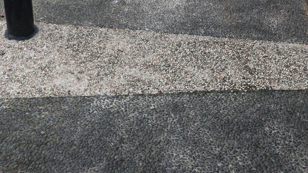 裸露的混凝土骨料，带有不同颜色的鹅卵石。城市公园的砾石地板。图片下载