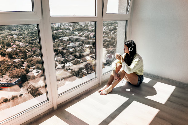 一个女人戴着耳机，手里拿着一杯咖啡图片下载