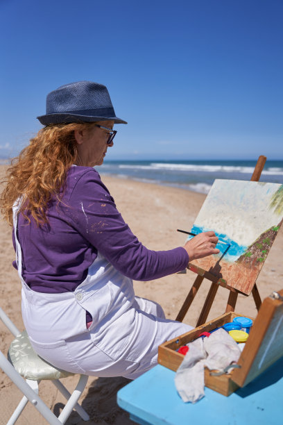 一位女士在沙滩上画画图片下载