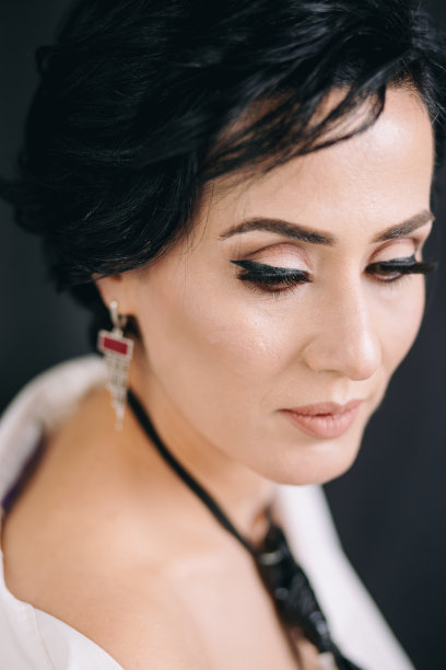 沉思的年轻女子穿着白衬衫，看上去若有所思，在摄影棚里摆姿势拍照图片下载