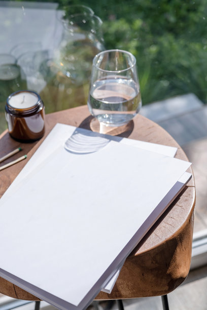 杂志和书籍的模型设计。空白杂志在现代木桌与蜡烛，阴影覆盖图片下载