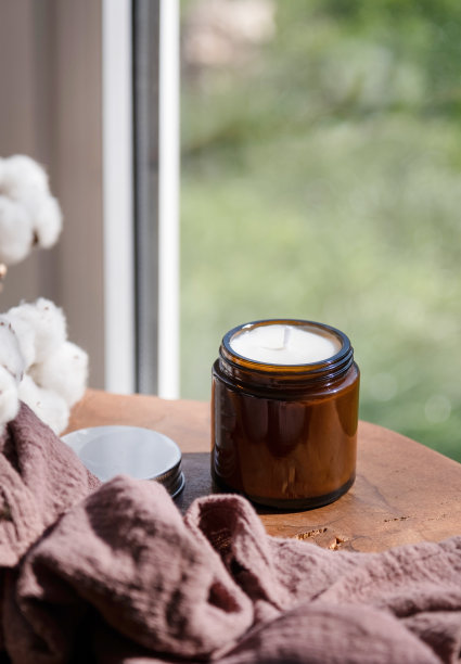 大豆蜡手工制作蜡烛在木桌和棉花枝，模拟设计图片下载