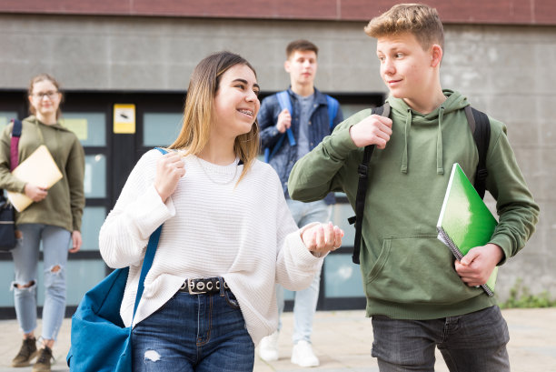 无忧无虑的青少年学生，男孩和女孩友好交谈图片下载
