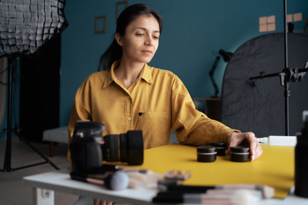 专业的摄影。摄影师用单反相机在家里的桌子上拍摄化妆品。摄影师家庭照相馆图片下载