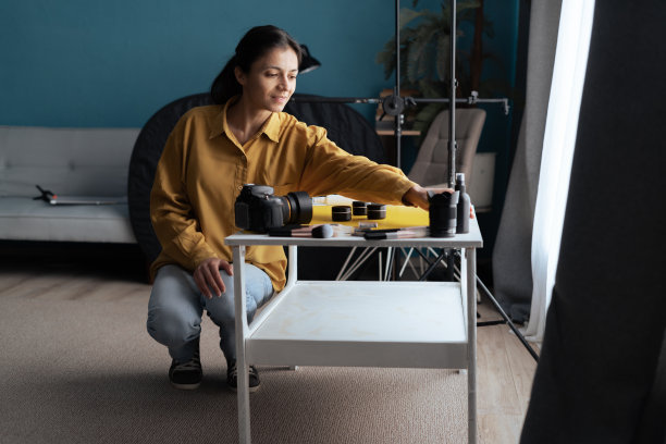 女美容产品摄影师拿着相机在家庭摄影棚准备拍摄。现代的博客。内容创造者。图片下载